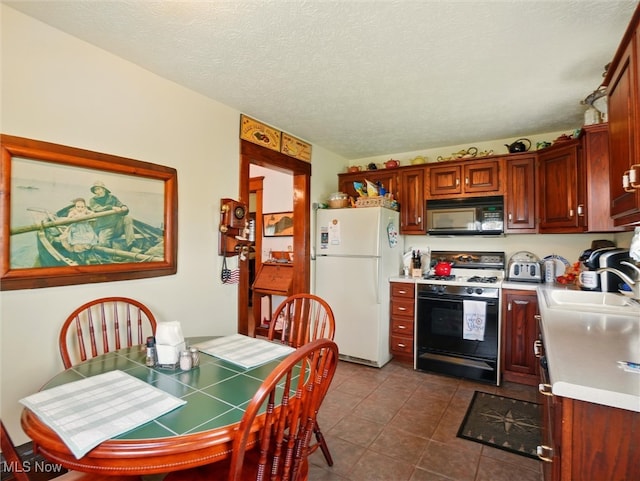 290-289 Park Ave, Conneaut, OH 44030 - kitchen featuring freestanding refrigerator, gas range, black microwave, light countertops, and dark tile patterned floors