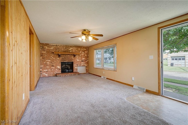 719 Pomeroy Pike, Belpre, OH 45714 - unfurnished living room with a brick fireplace, ceiling fan, plenty of natural light, carpet floors, and a textured ceiling