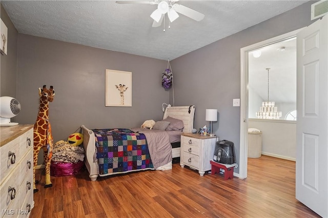 220 Long Rd, Macedonia, OH 44056 - bedroom with wood finished floors, a chandelier, ceiling fan, and a textured ceiling
