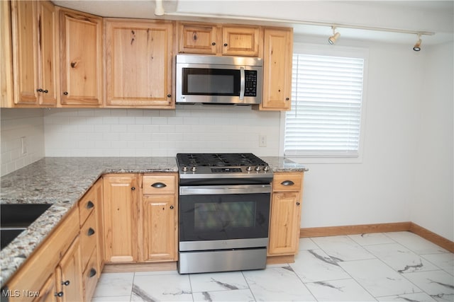 7355 Westview Dr, Boardman, OH 44512 - kitchen with stainless steel appliances, light marble finish flooring, light stone countertops, rail lighting, and backsplash