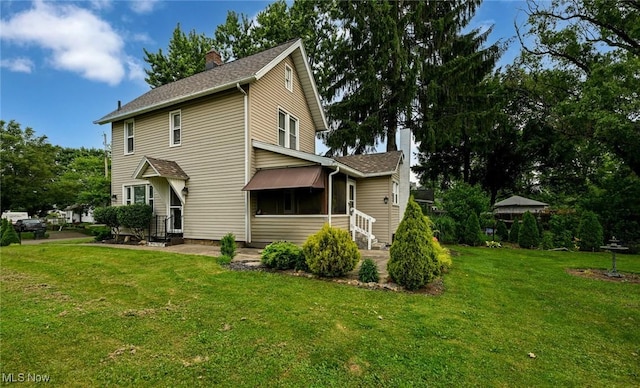 858 11th St NE, Massillon, OH 44646 - back of house featuring a chimney, entry steps, a yard, and roof with shingles