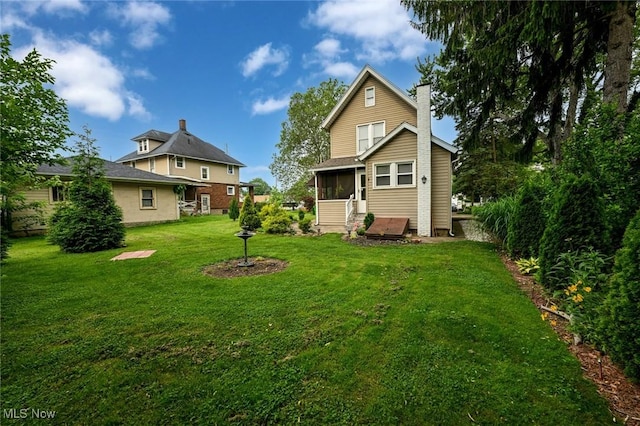 858 11th St NE, Massillon, OH 44646 - back of house with a chimney, a sunroom, and a yard