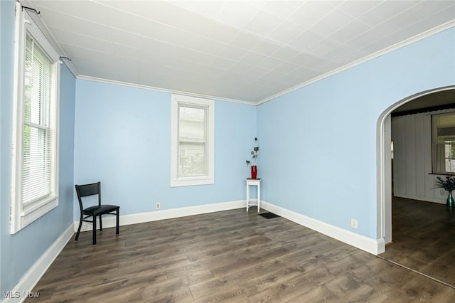 858 11th St NE, Massillon, OH 44646 - unfurnished room featuring ornamental molding, arched walkways, dark wood finished floors, and healthy amount of natural light