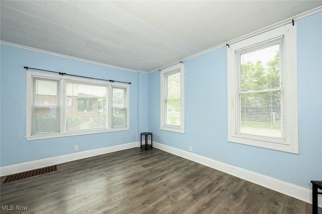 858 11th St NE, Massillon, OH 44646 - empty room featuring crown molding, dark wood finished floors, and healthy amount of natural light
