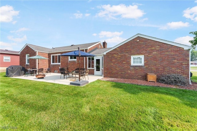 230 Hamilton Blvd, Struthers, OH 44471 - back of house featuring brick siding, a patio, a yard, and a chimney