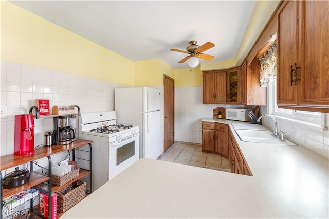 230 Hamilton Blvd, Struthers, OH 44471 - kitchen with white appliances, tile walls, brown cabinets, light countertops, and ceiling fan