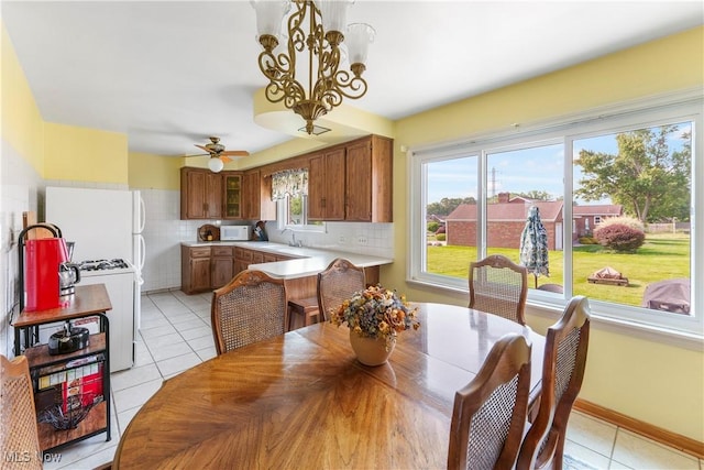 230 Hamilton Blvd, Struthers, OH 44471 - dining area with light tile patterned floors, a ceiling fan, and a chandelier