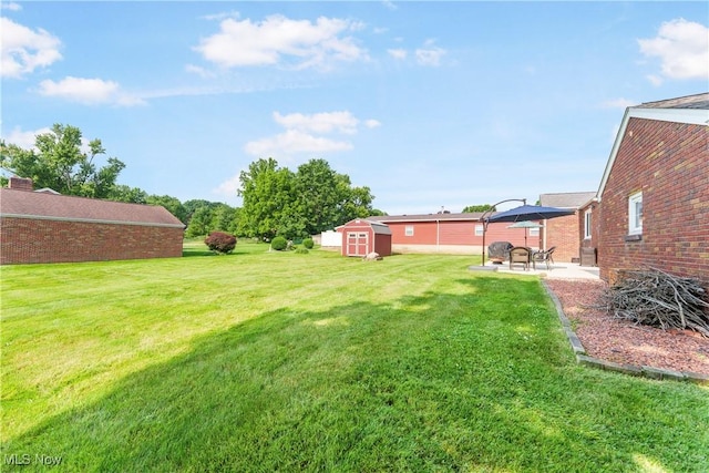 230 Hamilton Blvd, Struthers, OH 44471 - view of grassy yard with a storage unit and a patio area