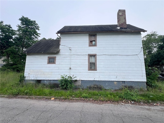 1055 E 78th St, Cleveland, OH 44103 - view of home's exterior with a chimney and a shingled roof
