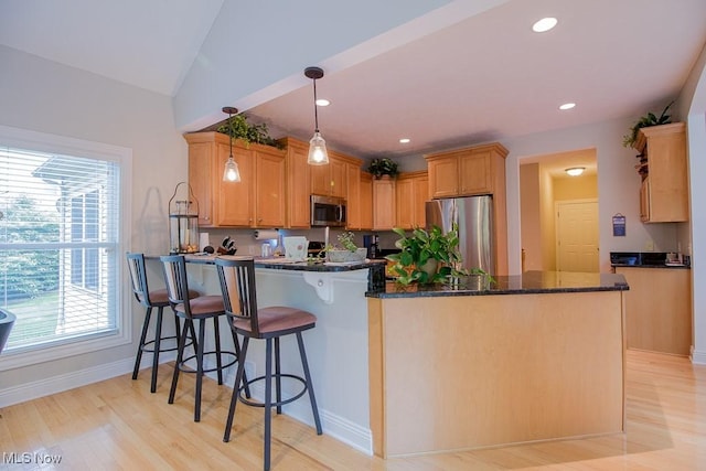 8311 Hemingway Ln, Mentor, OH 44060 - kitchen featuring appliances with stainless steel finishes, a peninsula, healthy amount of natural light, dark stone countertops, and recessed lighting