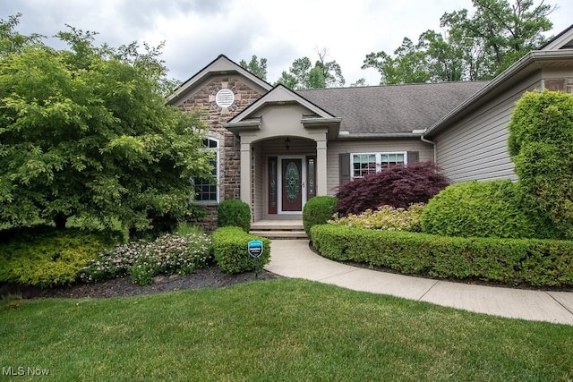 8311 Hemingway Ln, Mentor, OH 44060 - view of front facade featuring stone siding and a front lawn