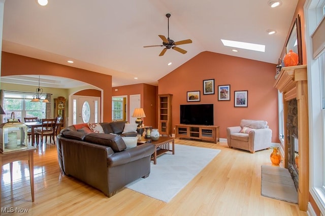 8311 Hemingway Ln, Mentor, OH 44060 - living room with a fireplace, ceiling fan, arched walkways, light wood finished floors, and high vaulted ceiling