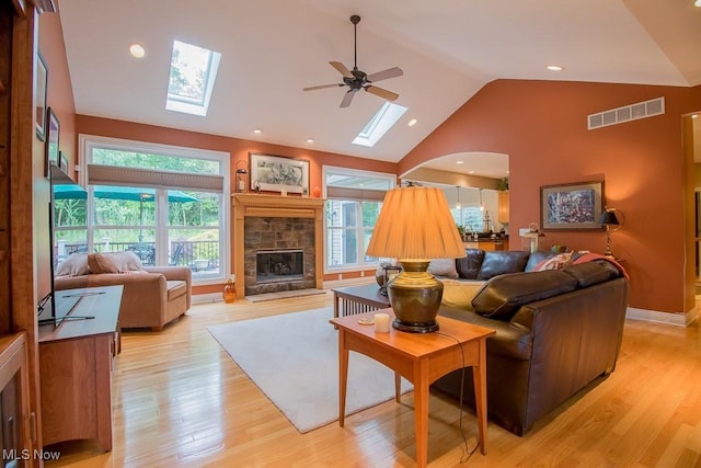 8311 Hemingway Ln, Mentor, OH 44060 - living room featuring a skylight, ceiling fan, a fireplace, light wood finished floors, and high vaulted ceiling