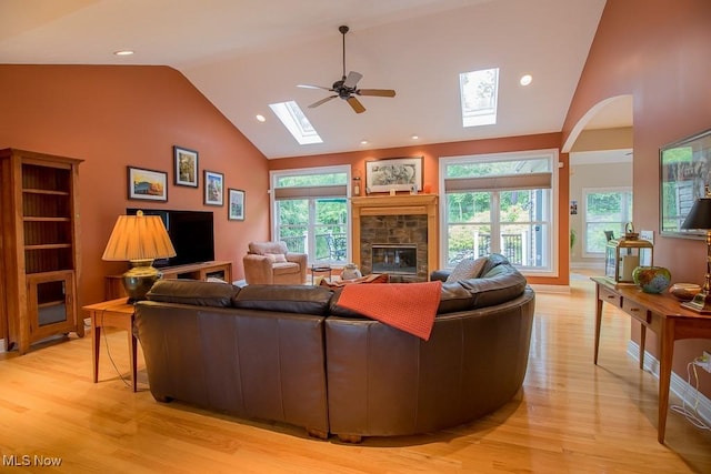 8311 Hemingway Ln, Mentor, OH 44060 - living room featuring a skylight, light wood finished floors, a fireplace, ceiling fan, and high vaulted ceiling