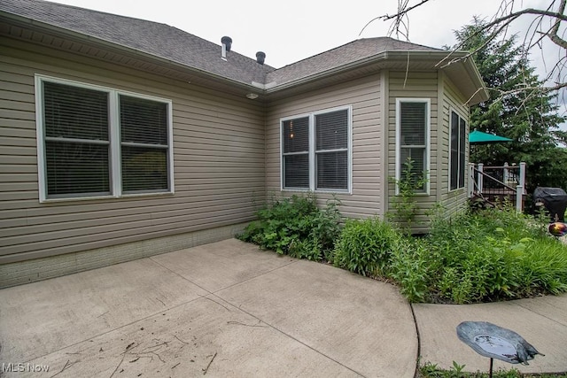 8311 Hemingway Ln, Mentor, OH 44060 - view of side of property featuring a patio and roof with shingles
