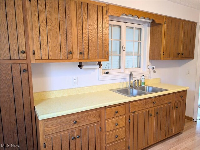 173 6th St SW, Brewster, OH 44613 - kitchen with light countertops, brown cabinets, and light wood finished floors