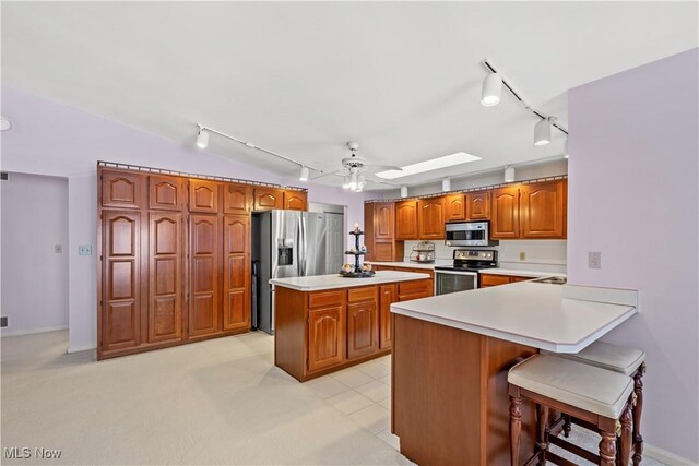52 Hilda Cir, Bloomingdale, OH 43910 - kitchen featuring stainless steel appliances, track lighting, brown cabinetry, light countertops, and a ceiling fan
