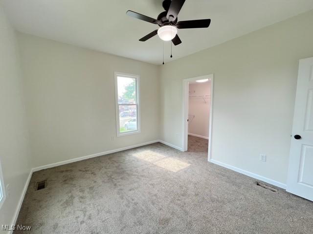 619 N 3rd St, Dennison, OH 44621 - unfurnished bedroom with carpet floors, a walk in closet, ceiling fan, and a closet