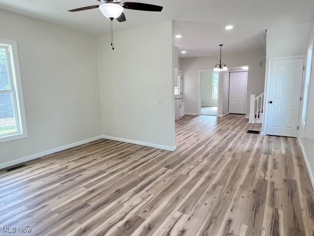 619 N 3rd St, Dennison, OH 44621 - empty room featuring light wood finished floors, a ceiling fan, recessed lighting, and a chandelier