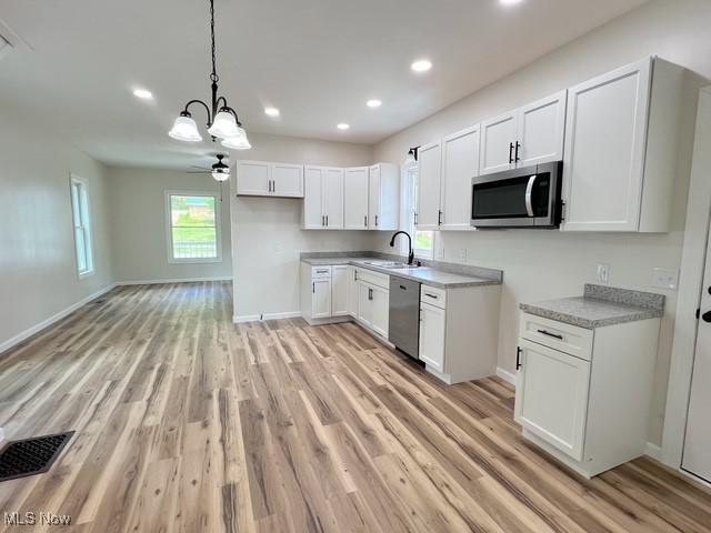 619 N 3rd St, Dennison, OH 44621 - kitchen with stainless steel appliances, a chandelier, light wood finished floors, recessed lighting, and white cabinets
