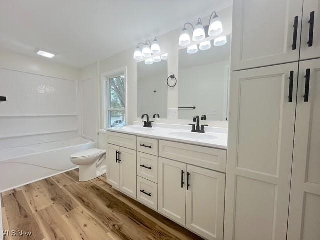 619 N 3rd St, Dennison, OH 44621 - full bathroom with wood finished floors, double vanity, and shower / bath combination