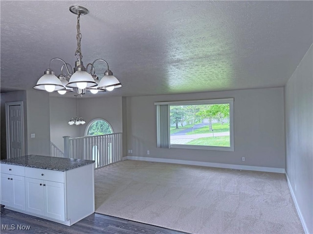 7247 Kiltie Ln, Northfield, OH 44067 - kitchen featuring a chandelier, white cabinetry, a textured ceiling, hanging light fixtures, and a center island