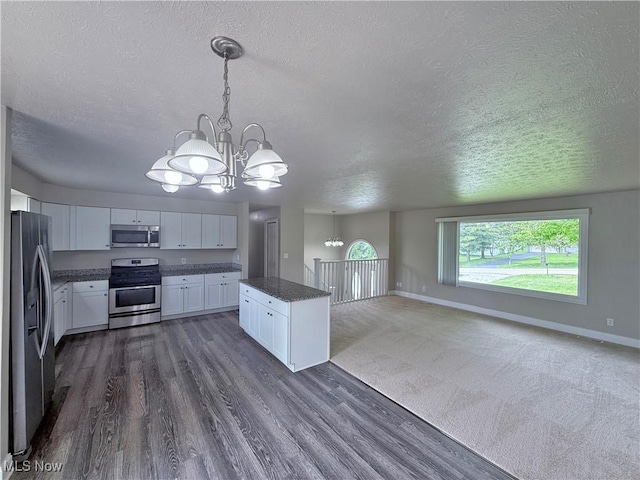7247 Kiltie Ln, Northfield, OH 44067 - kitchen featuring stainless steel appliances, a chandelier, a textured ceiling, white cabinetry, and dark wood-style flooring