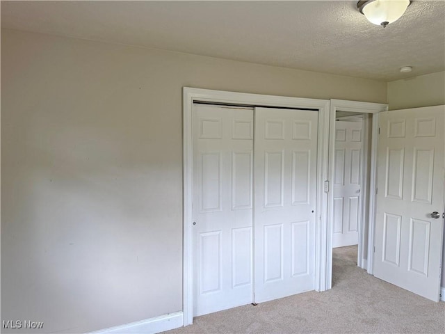 7247 Kiltie Ln, Northfield, OH 44067 - unfurnished bedroom featuring light carpet, a closet, and a textured ceiling