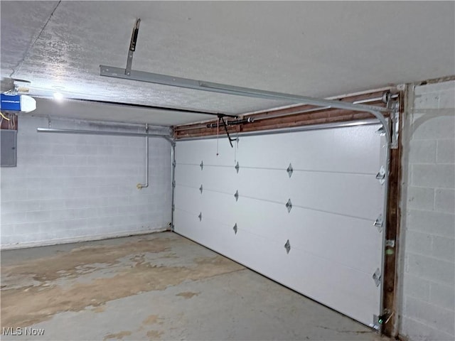 7247 Kiltie Ln, Northfield, OH 44067 - garage with electric panel, a garage door opener, and concrete block wall