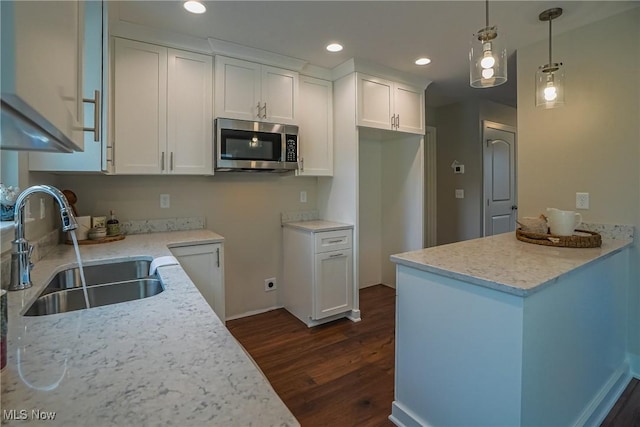 583 Creedmore Ave, Barberton, OH 44203 - kitchen with stainless steel microwave, dark wood-style floors, white cabinets, recessed lighting, and pendant lighting
