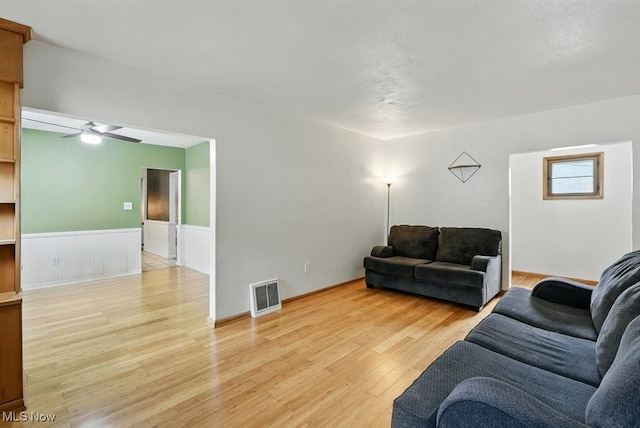 447 Allenford St, Akron, OH 44314 - living area with light wood-style floors, a ceiling fan, and a wainscoted wall