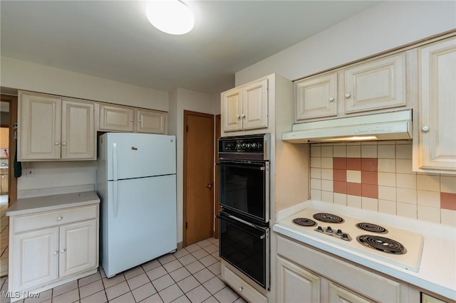 2375 Glendon Rd, University Heights, OH 44118 - kitchen with white appliances, under cabinet range hood, light countertops, tasteful backsplash, and light tile patterned flooring