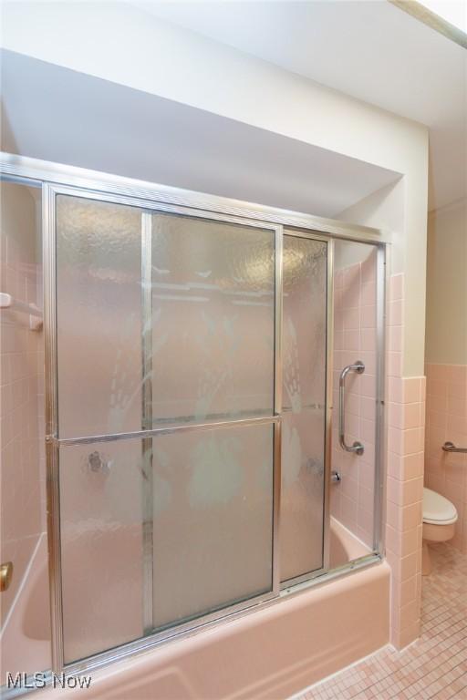 2375 Glendon Rd, University Heights, OH 44118 - full bath with enclosed tub / shower combo, tile patterned flooring, tile walls, and a wainscoted wall