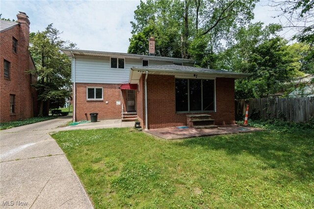 2375 Glendon Rd, University Heights, OH 44118 - rear view of property with entry steps, brick siding, a chimney, and concrete driveway