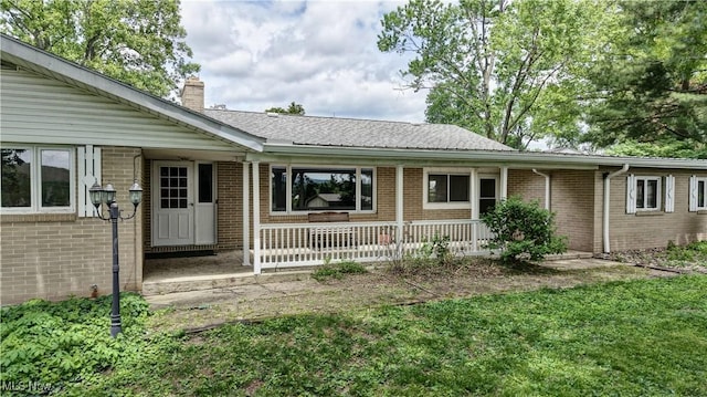 1592 Pleasant Vw, Dover, OH 44612 - view of front facade with a porch, a chimney, brick siding, and a front lawn