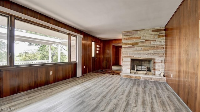 1592 Pleasant Vw, Dover, OH 44612 - unfurnished living room featuring wood finished floors, wood walls, and a stone fireplace