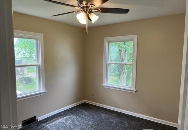 920 Washington Ave, Girard, OH 44420 - empty room featuring plenty of natural light, dark colored carpet, and ceiling fan