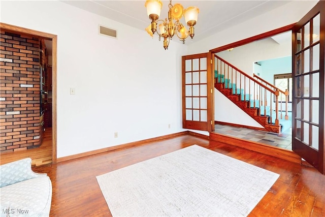 5864 State Route 213, Toronto, OH 43964 - unfurnished living room with wood finished floors, a chandelier, stairs, and french doors