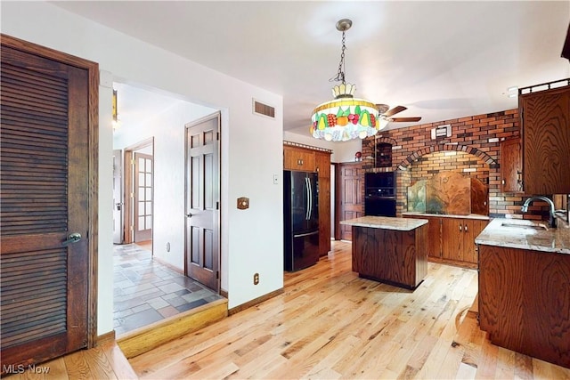 5864 State Route 213, Toronto, OH 43964 - kitchen featuring freestanding refrigerator, a ceiling fan, a kitchen island, light wood finished floors, and brown cabinetry
