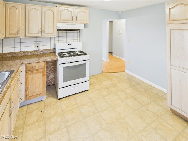 1317 Crescent St, Parkersburg, WV 26101 - kitchen with white gas range oven, under cabinet range hood, light brown cabinetry, and decorative backsplash