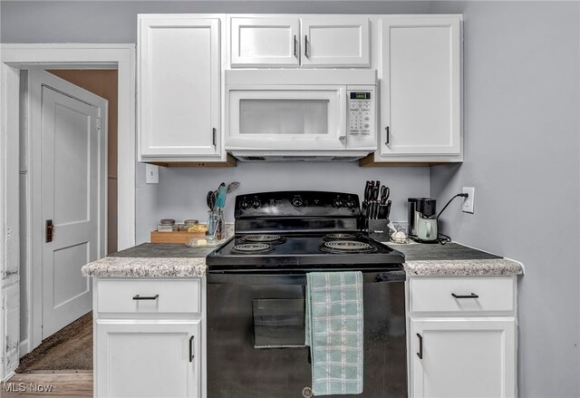 4532 W 172nd St, Cleveland, OH 44135 - kitchen with white microwave, black / electric stove, white cabinets, and light countertops