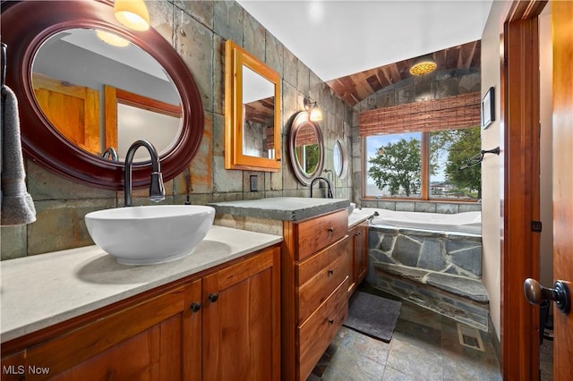 731 Cedar Point Rd, Sandusky, OH 44870 - full bathroom featuring double vanity, a bath, vaulted ceiling, and stone finish flooring