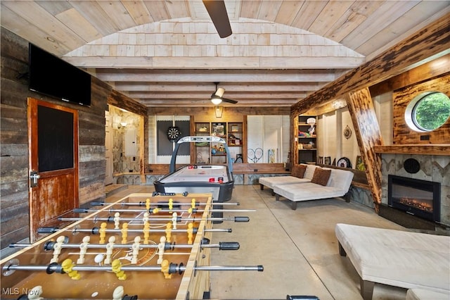 731 Cedar Point Rd, Sandusky, OH 44870 - rec room featuring vaulted ceiling, wooden walls, concrete flooring, a ceiling fan, and a glass covered fireplace