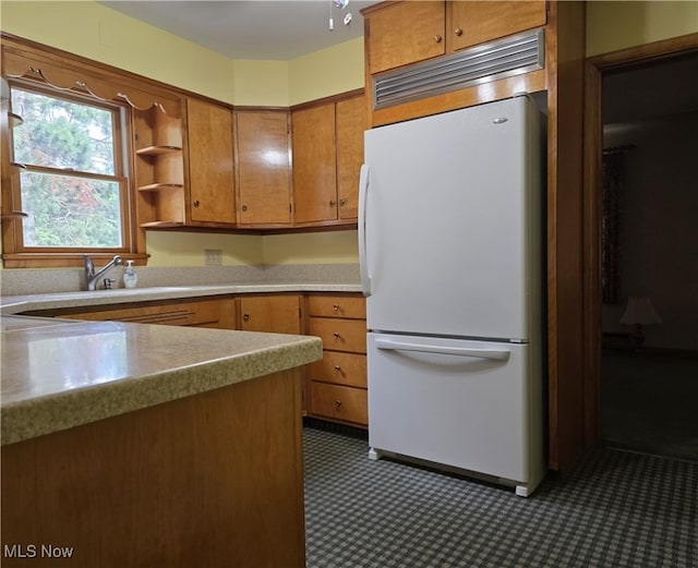 36277 Butcher Rd, Salem, OH 44460 - kitchen with freestanding refrigerator, brown cabinetry, light countertops, and open shelves