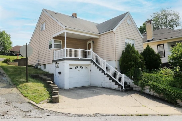 417 Logan Ave, Mingo Junction, OH 43938 - view of front facade with stairs, an attached garage, a porch, and driveway