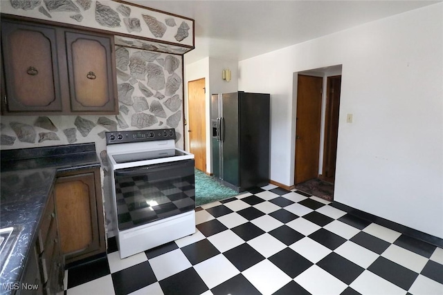 417 Logan Ave, Mingo Junction, OH 43938 - kitchen featuring white range with electric stovetop, black fridge, light floors, and dark countertops