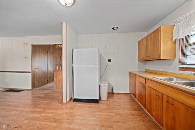 2100 Priscilla Ave NW, Massillon, OH 44647 - kitchen with freestanding refrigerator, light wood-style floors, light countertops, and brown cabinetry