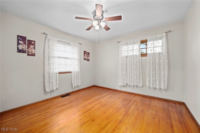 2100 Priscilla Ave NW, Massillon, OH 44647 - unfurnished room featuring healthy amount of natural light, light wood-style floors, and a ceiling fan