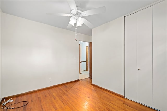 2100 Priscilla Ave NW, Massillon, OH 44647 - unfurnished bedroom featuring a closet, light wood-type flooring, and a ceiling fan