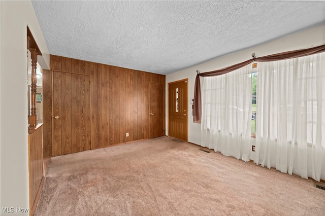 2100 Priscilla Ave NW, Massillon, OH 44647 - empty room with carpet flooring, wooden walls, and a textured ceiling